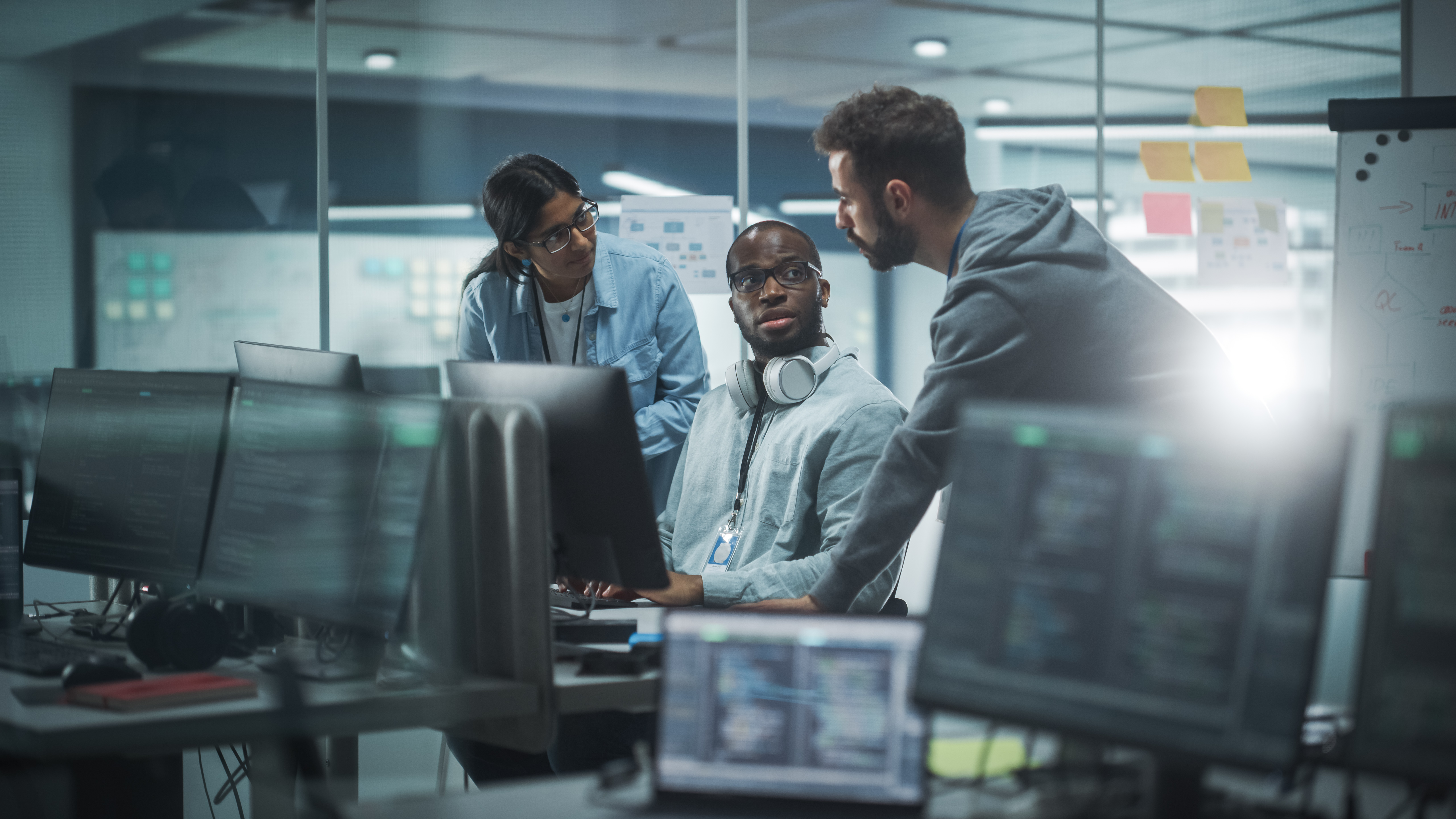 Diverse Group Of Professionals Meeting In Modern Office: Brainstorming It Programmers Use Computer Together, Talk Strategy, Discuss Planning Software Engineers Develop Inspirational App Program